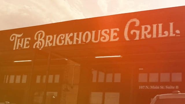 Group of friends gathering at an outdoor patio at The Brickhouse Grill in Joshua, watching the game and enjoying food and drinks