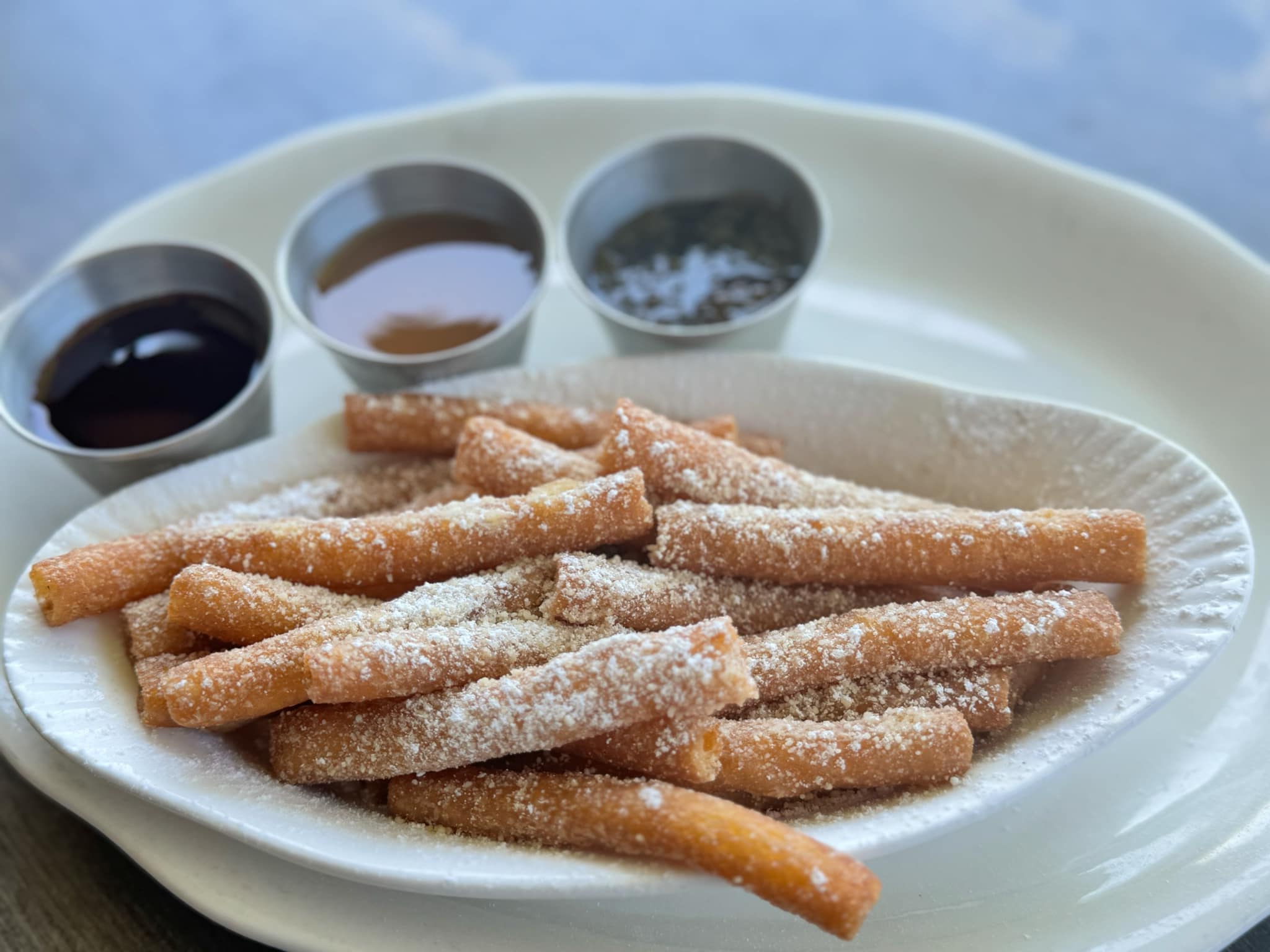 Crispy funnel cake fries dusted with powdered sugar and served with three dipping sauces.